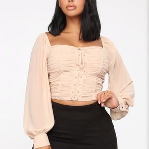 Nude ruffled top with mesh sleeves.